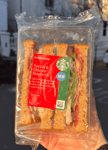 Hand holding the starbucks christmas sandwich from 2023